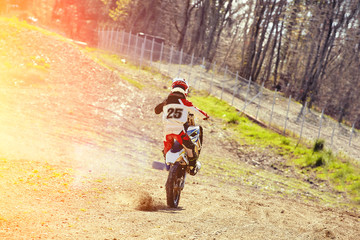 Motocross, a rider stands on the rear wheel of a bike, Riding on the rear wheel. Extreme, industrial, motorcycle cross-country riding for extreme.