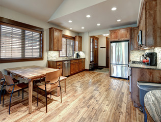 Luxury middle tone wood rich kitchen interior with grey natural stone  tiles backsplash and quarts countertop.