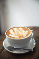 cappuccino or Latte art coffee made from milk on the wood table in coffee shop