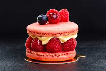 raspberry macaron. Cake with raspberries and cream on a black background.