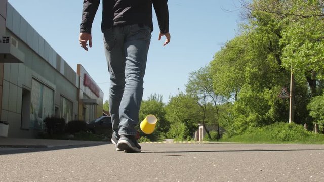 A man throws out paper cup on the ground