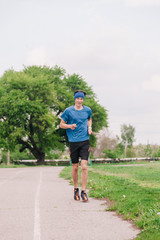 Obraz premium A young athlete in a blue T-shirt runs around the stadium