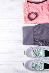 grey sneakers, leggings, pink top, sports bracelet, sportswear on a white