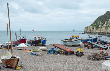 Part of the local fishing fleet stranded on the pebble beach at Beer in south east Devon, UK. Vessels are towed to and from the sea by tractor