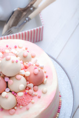 Pink birthday cake with marshmallow on a plate. Close-up, top view