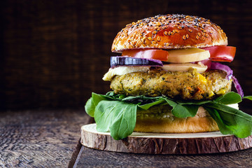 vegan burger on rustic wooden table, with vegetable burger and meat flavor. Healthy vegan food.