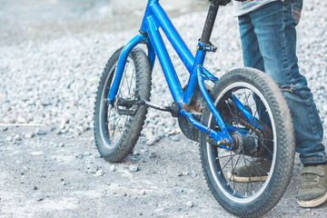 boy stands near his bike