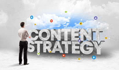 Young businessman standing in front of CONTENT STRATEGY inscription, social media concept