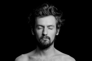 portrait of a guy with a beard and tousled hair on a black background