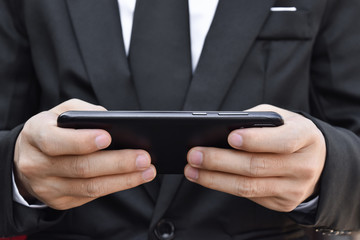 Close up of man using smartphone playing mobile game. Business and technology concept.