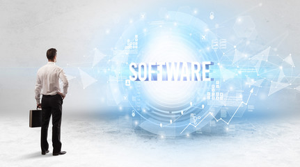 Rear view of a businessman standing in front of SOFTWARE inscription, modern technology concept