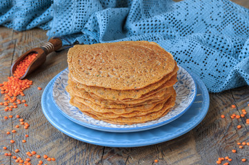 Stack of homemade  vegan red lentil  tortillas on plate on wooden table.  Selective focus.
