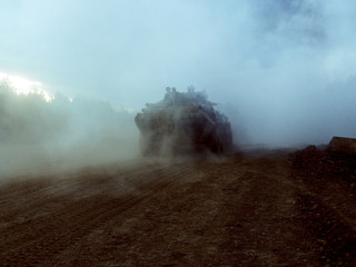 Fototapeta na wymiar Tanks are moving to firing positions. Smoke bombs action. Battlefield. Sandstorm. Storm.