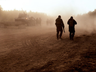 Tanks at firing positions. Battlefield. Sandstorm. A group of soldiers on a field position. Smoke...