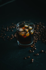 Cold Brew Coffee in Whiskey glass on a countertop with coffee beans