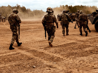 Tanks are moving to firing positions. A group of soldiers. A group of soldiers on a field position.