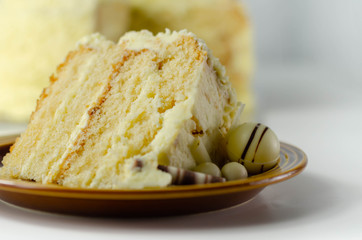 A piece of layered white cream cake with confectionery decorations