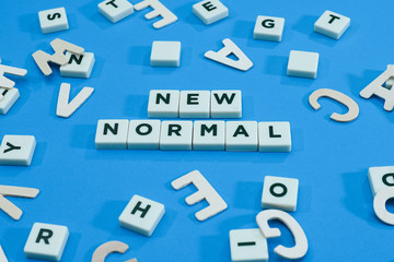 Block letters text on new normal on blue background
