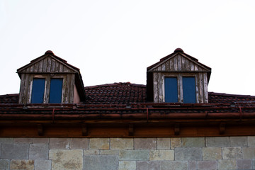 Roof top on sky background. Close up of brown clay roof tiles. Red old dirty roof. Old roof tiles