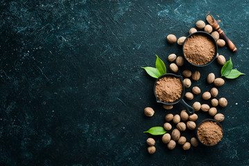 Ground nutmeg in bowl on black stone background. Fragrant Indian spices. Free space for your text....