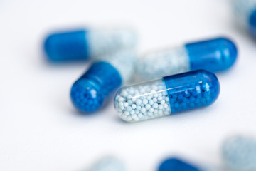 Blue capsule, pills on white background
