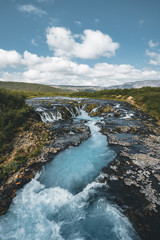 Incredible view of Bruarfoss Waterfall. The 'Iceland s Bluest Waterfall.' Blue water flows over stones. Midnight sun of Iceland. Visit Iceland. Beauty world.