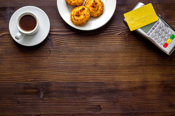 Payment by credit card. Terminal on wooden restaurant desk top view copy space