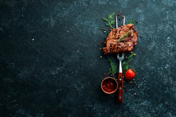 Baked pork steak on a fork. Barbecue menu. Top view.