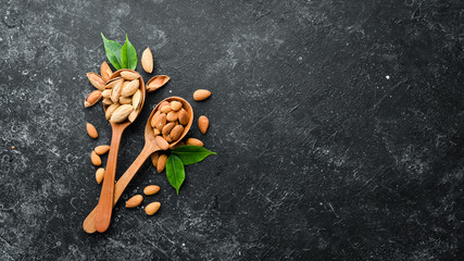 Almond nut in a wooden spoon. Top view. Free space for your text.