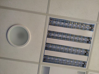 Accoustic panel and light fixtures in t-bar grid of suspended ceiling