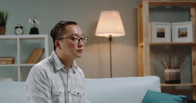 Sick young asian man sitting at home and coughing because he is infected with flu - coronavirus, desease carrier concept 4k footage