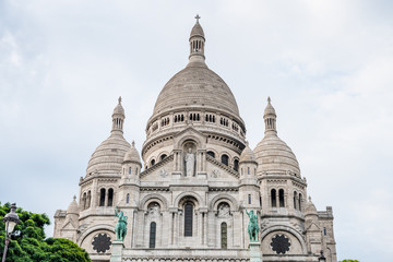 Fototapeta premium The Basilica of the Sacred Heart of Paris, at the summit of the butte Montmartre, the highest point in Paris, France