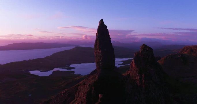 Stunning dramatic rock formations at Old Man Storr, Scotland at sunrise with long shadows and red landscape