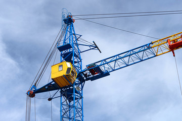 The cabin of high-rise construction cranes against the blue sky.