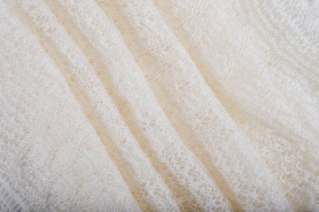 Fototapeta na wymiar top view closeup folded openwork binding beige, knitted, woolen shawl with pattern