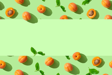 Trendy summer pattern with ripe apricots on green background. Minimal summer concept. Wallpaper, sale, discount, natural cosmetics banner background. Copy space
