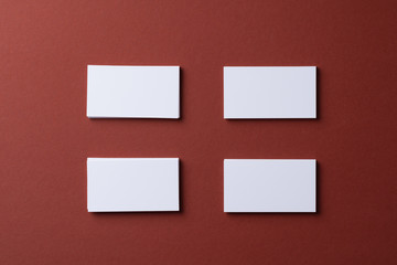 Blank white business cards on burgundy paper background
