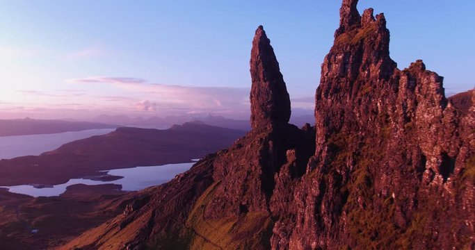 Flying through the rocks at Old Man Storr, at sunrise. Gorgeous view over valley and at red tinted rocks and mountains