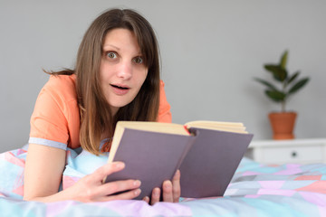 The girl in a slight shock from reading in a book