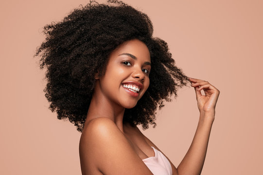 Happy black woman touching clean hair