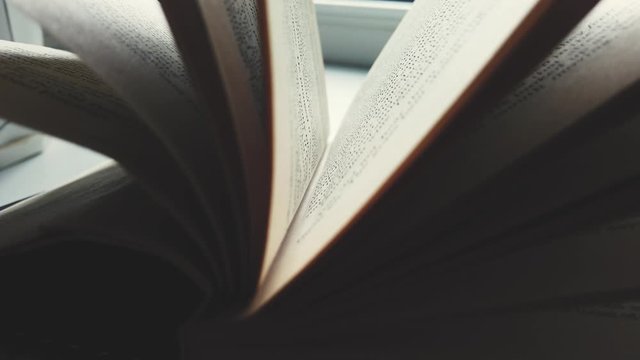 Close-up of an open book. Macro photography of pages and text in dynamics