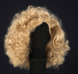 Long blonde hair wig isolated on black background