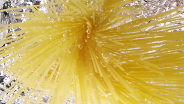 Spaghetti throwing into the water. Pasta falling into boiled water. Look up view. Slow motion.
