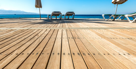 Morning and relaxing atmosphere  with wooden floor at a public beach on the Red Sea. Concept of blessing summer vacations in the Middle East 