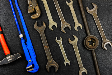 Hand tools for plumbing and parts on black background. Set for locksmith or plumber.