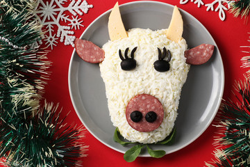 Festive Bull-shaped salad for 2021 on red background, Symbolic food for new year, Top view,...