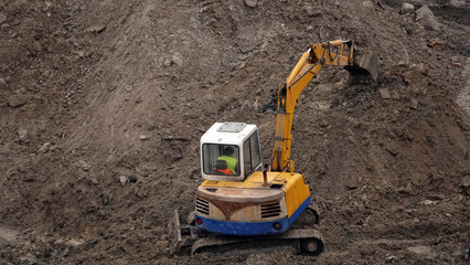 Tractors and excavators work on the construction of the foundation zero cycle