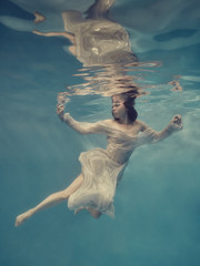 Portrait of a girl in a dress floating underwater