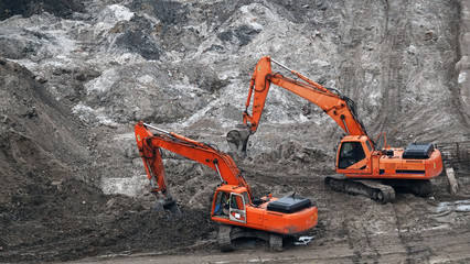 Tractors and excavators work on the construction of the foundation zero cycle