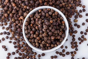 fragrant black pepper on white acrylic background